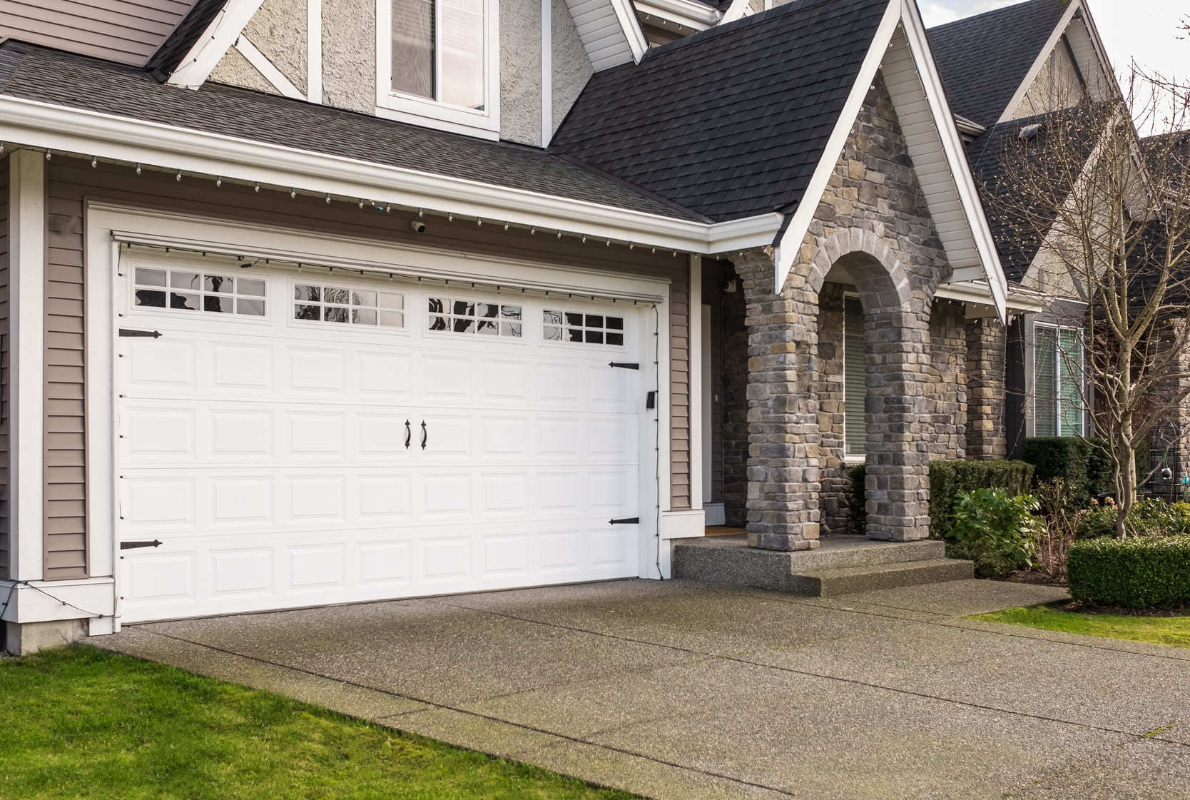 Beautiful stone home with a large white garage door
